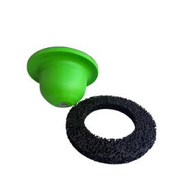 Das Bild zeigt einen grnen, kuppelfrmigen Gegenstand und daneben eine schwarze, flache, ringfrmige Scheibe mit grober, schwammartiger Struktur.